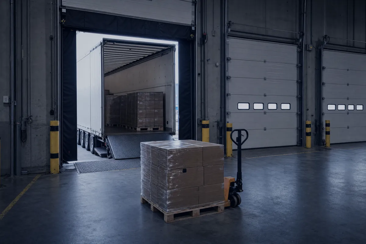 Logistiklager mit Laderampe, Lkw-Auflieger und Paletten im Morgenlicht